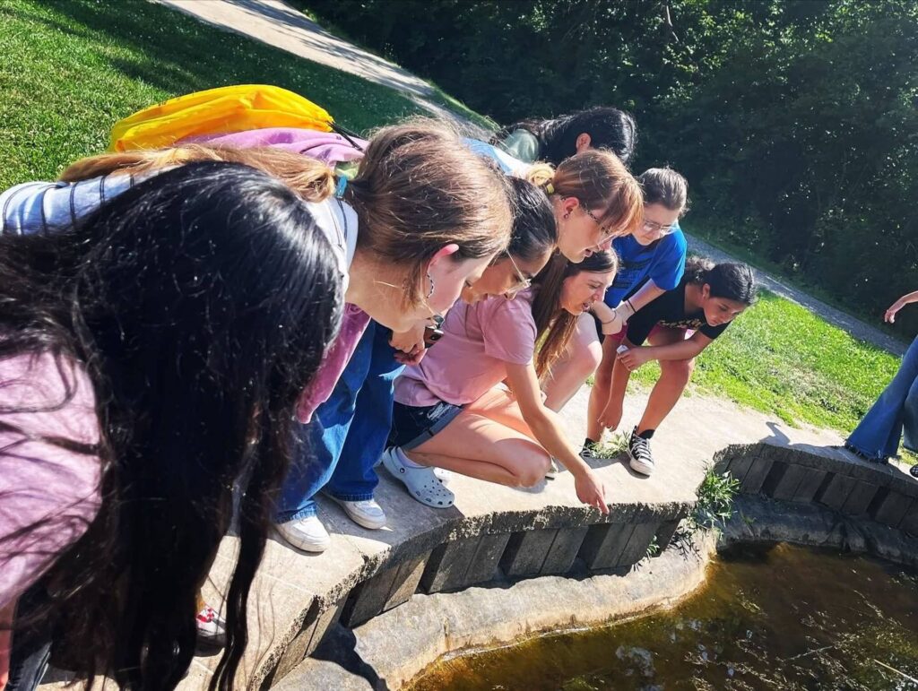 Group of kids gathered around a fountain.