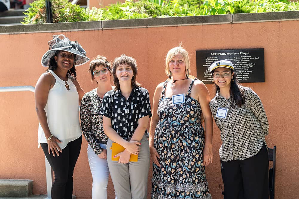 Group of women standing outside smiling at camera.