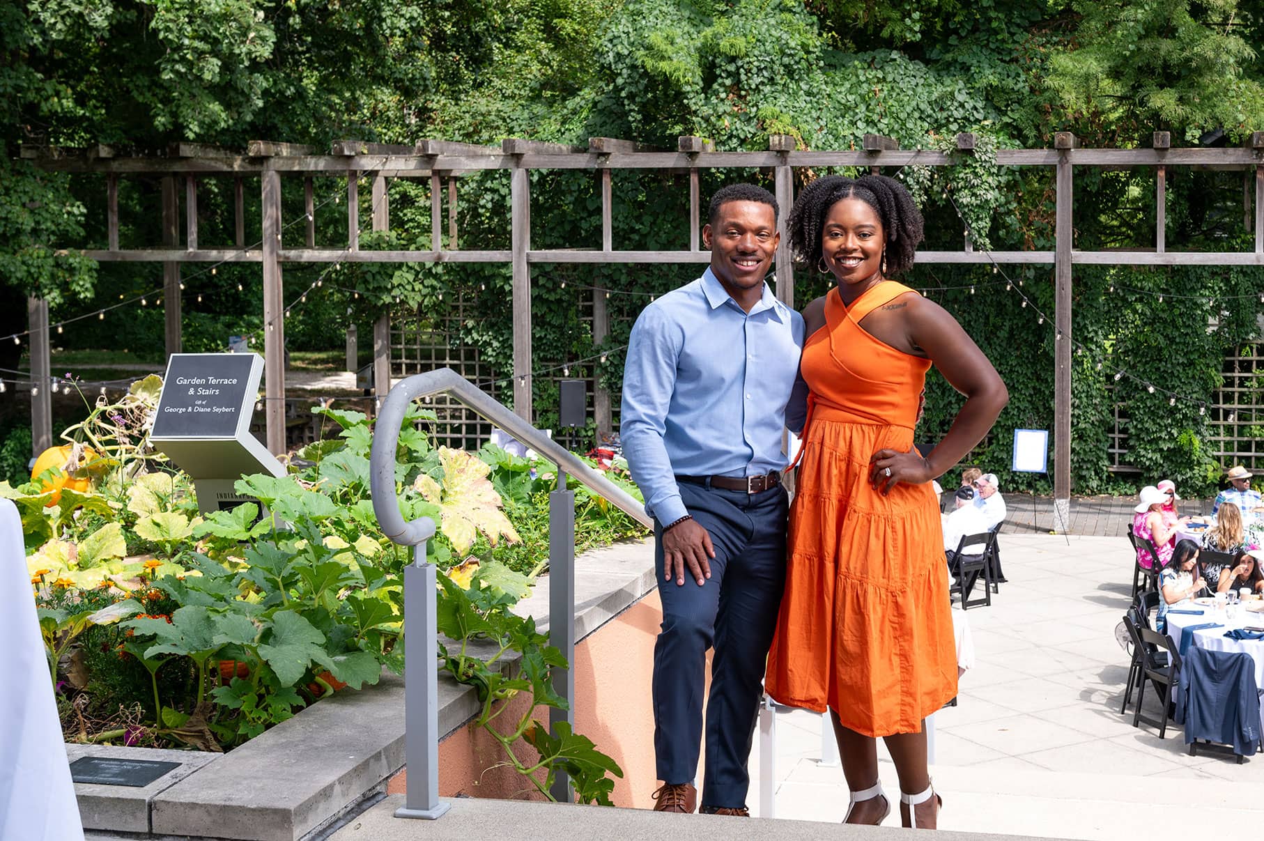 Couple standing in garden smiling at camera