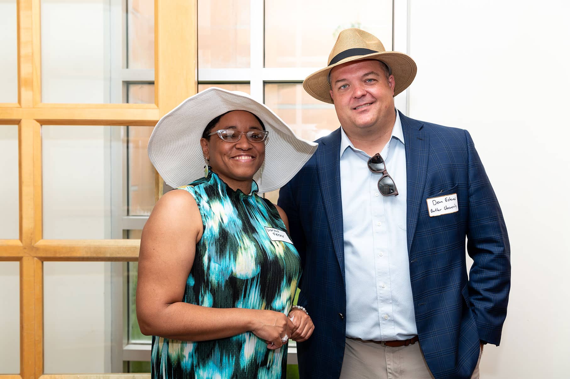 Couple wearing large hats, smiling at camera.